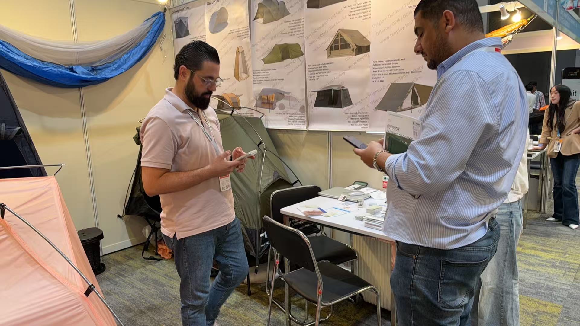 Visitors beside an olive-green tent and product information at the Tenplay booth